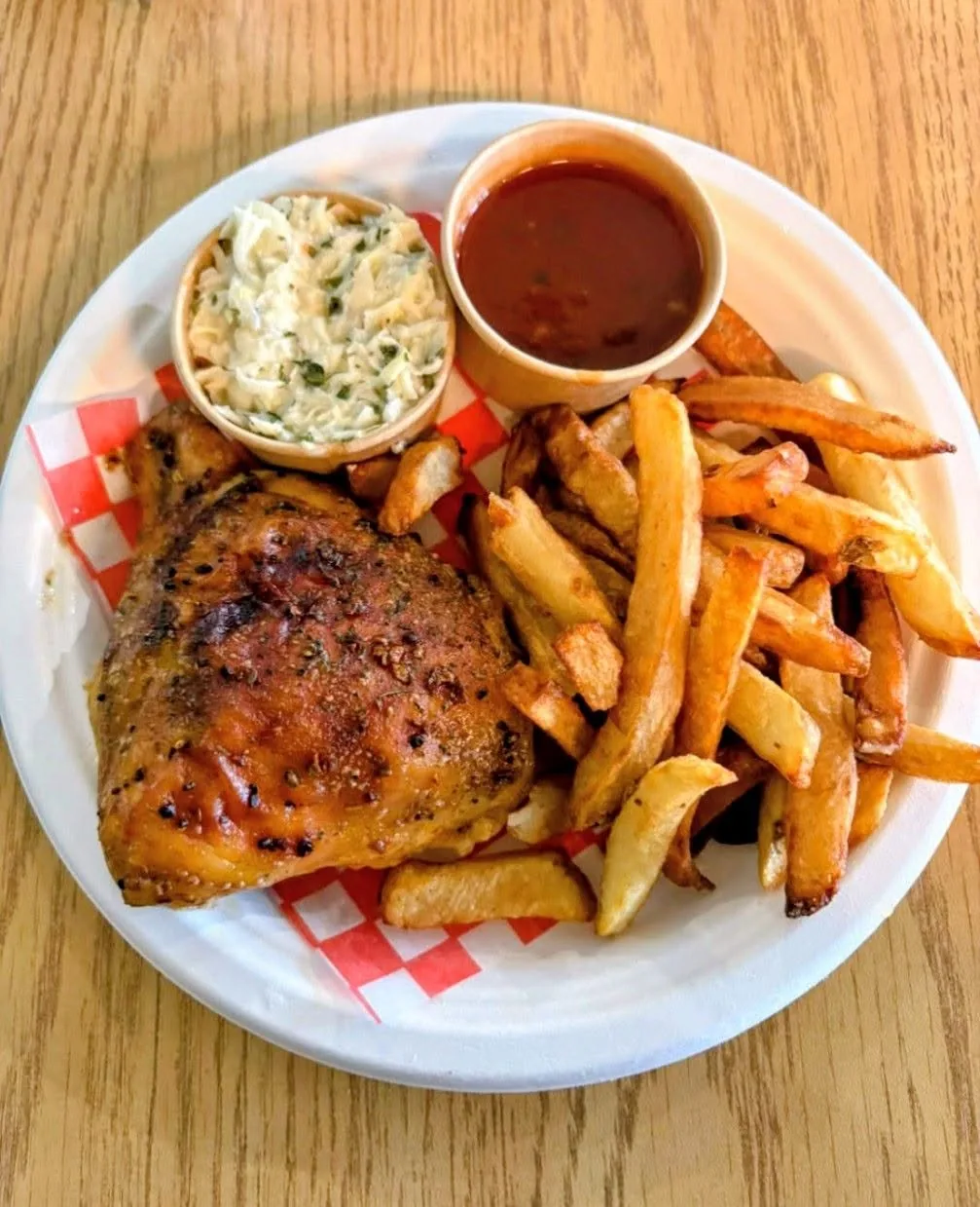 Quart de poulet grillé servi avec frites maison, salade de chou et sauce BBQ